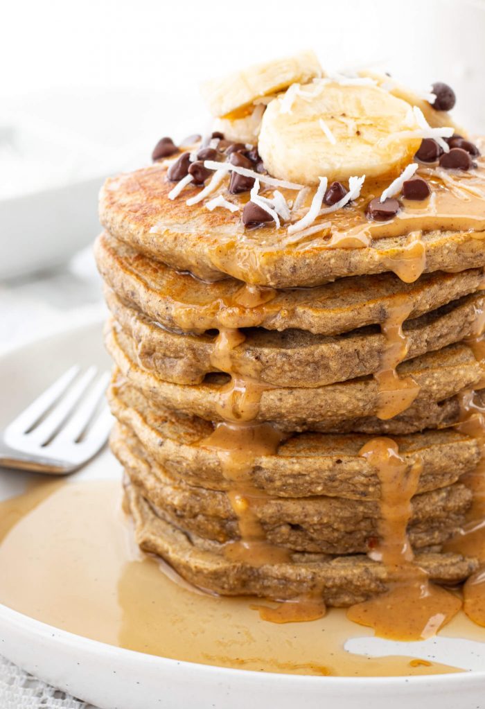 stack of protein pancakes with banana, peanut butter and chocolate chips