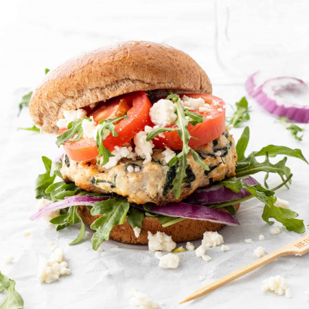 A chicken feta burger served with fresh toppings