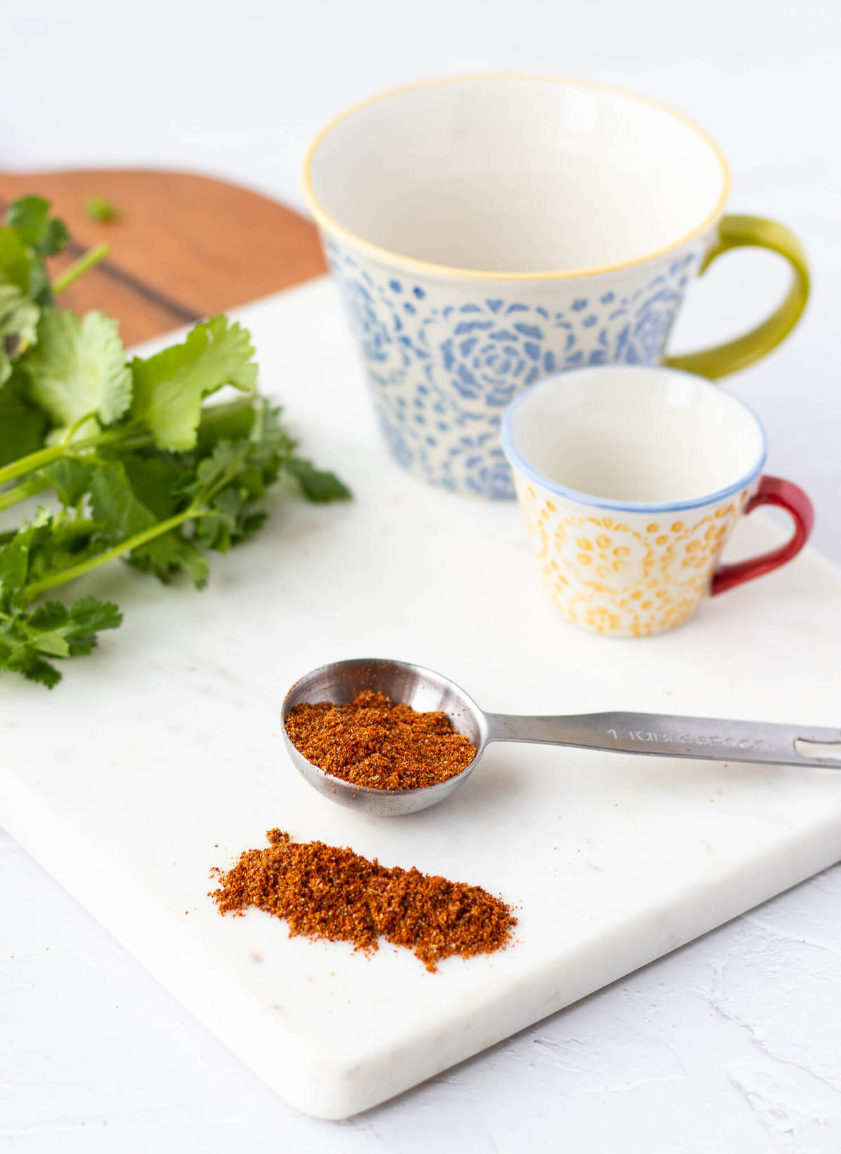 Healthy Homemade Taco Seasoning on a cutting board and a measuring spoon