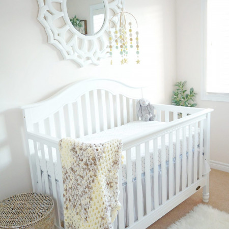 A beautiful white crib in a gender neutral baby nursery