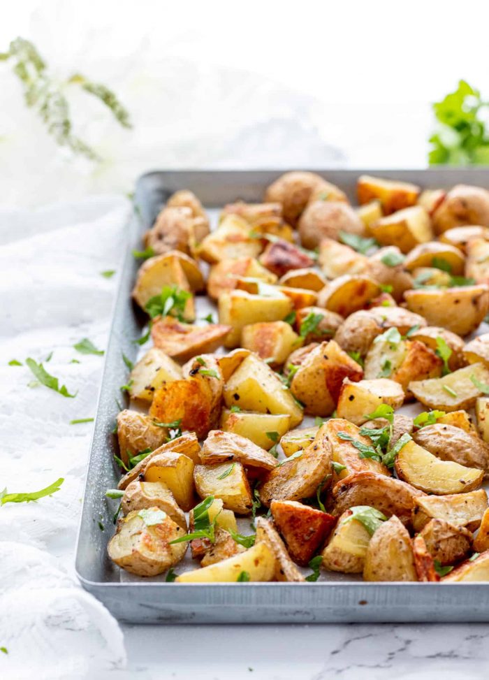 roasted potatoes on a baking sheet with fresh parsley