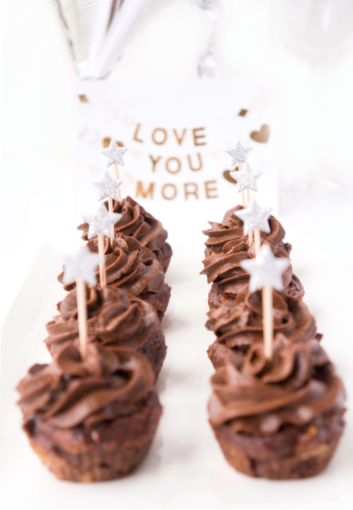 Two lines of No-Sugar Added Chocolate Brownie Cupcakes in front of a sign that says \"Love You More\"