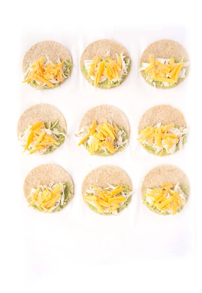 Small tortilla circles with quesadilla toppings on one side