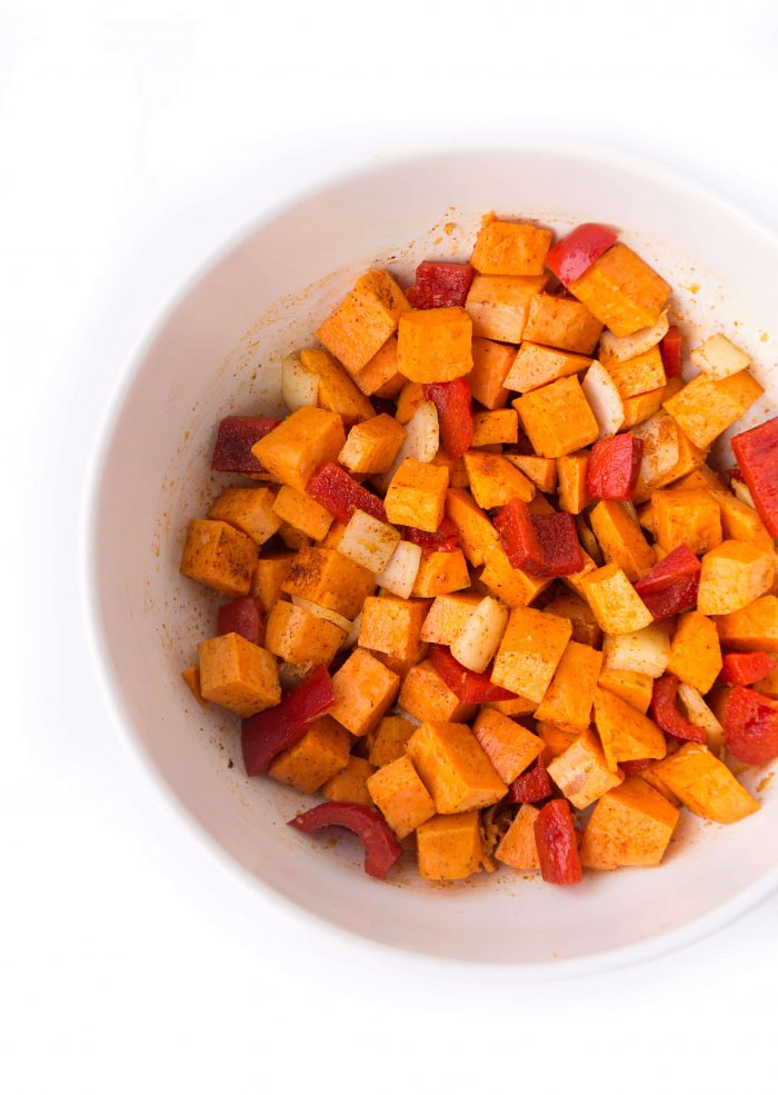 Bowl of diced sweet potato, onion, and red pepper, seasoned