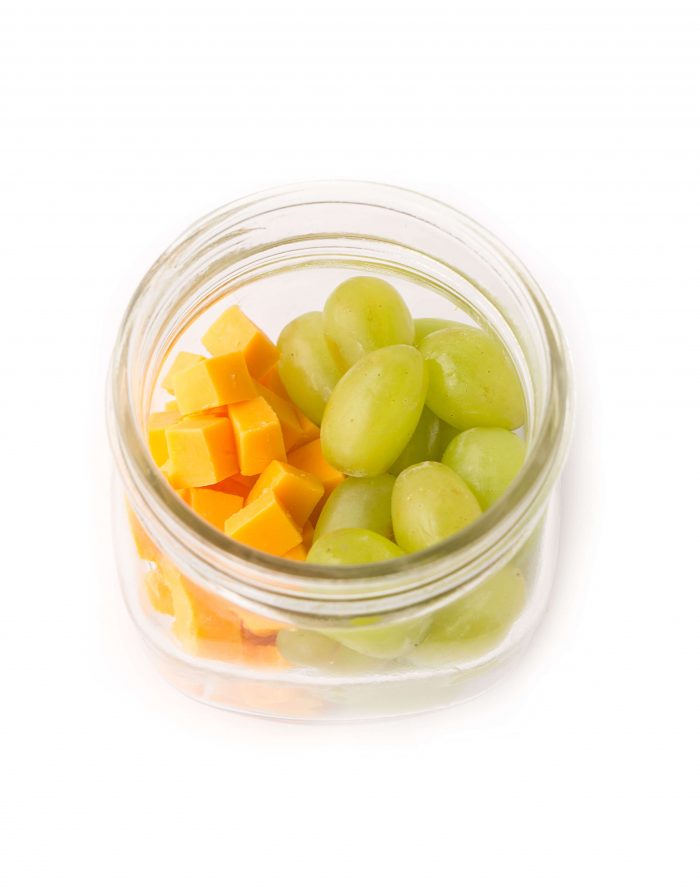 Mason jar filled with green grapes and cheese