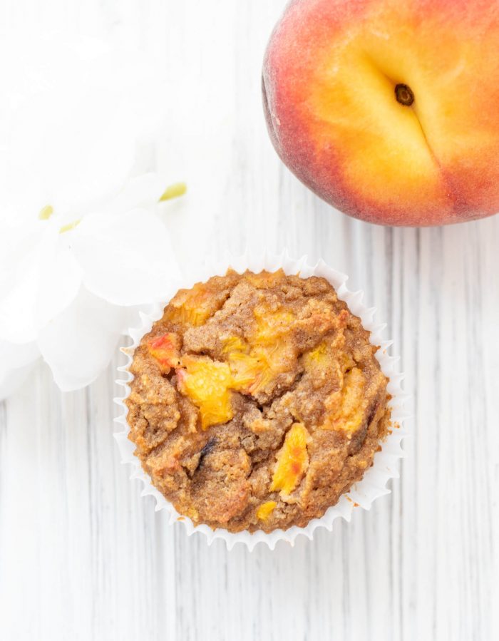 Overhead shot of a Gluten-free Peach Vanilla Muffin with a peach