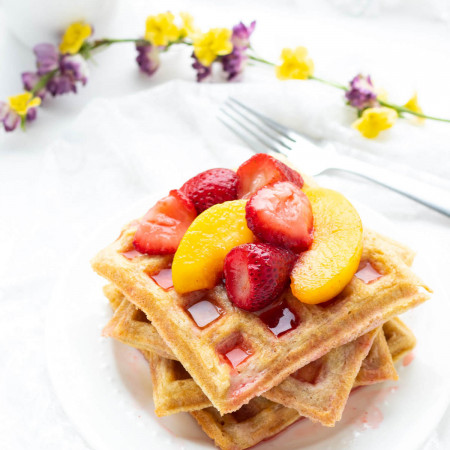 Stack of Paleo Waffles piled with fruit on a plate