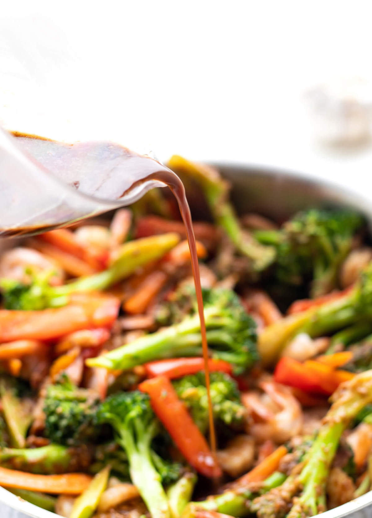 Healthy Stir Fry Sauce being poured onto stir fry in a pan