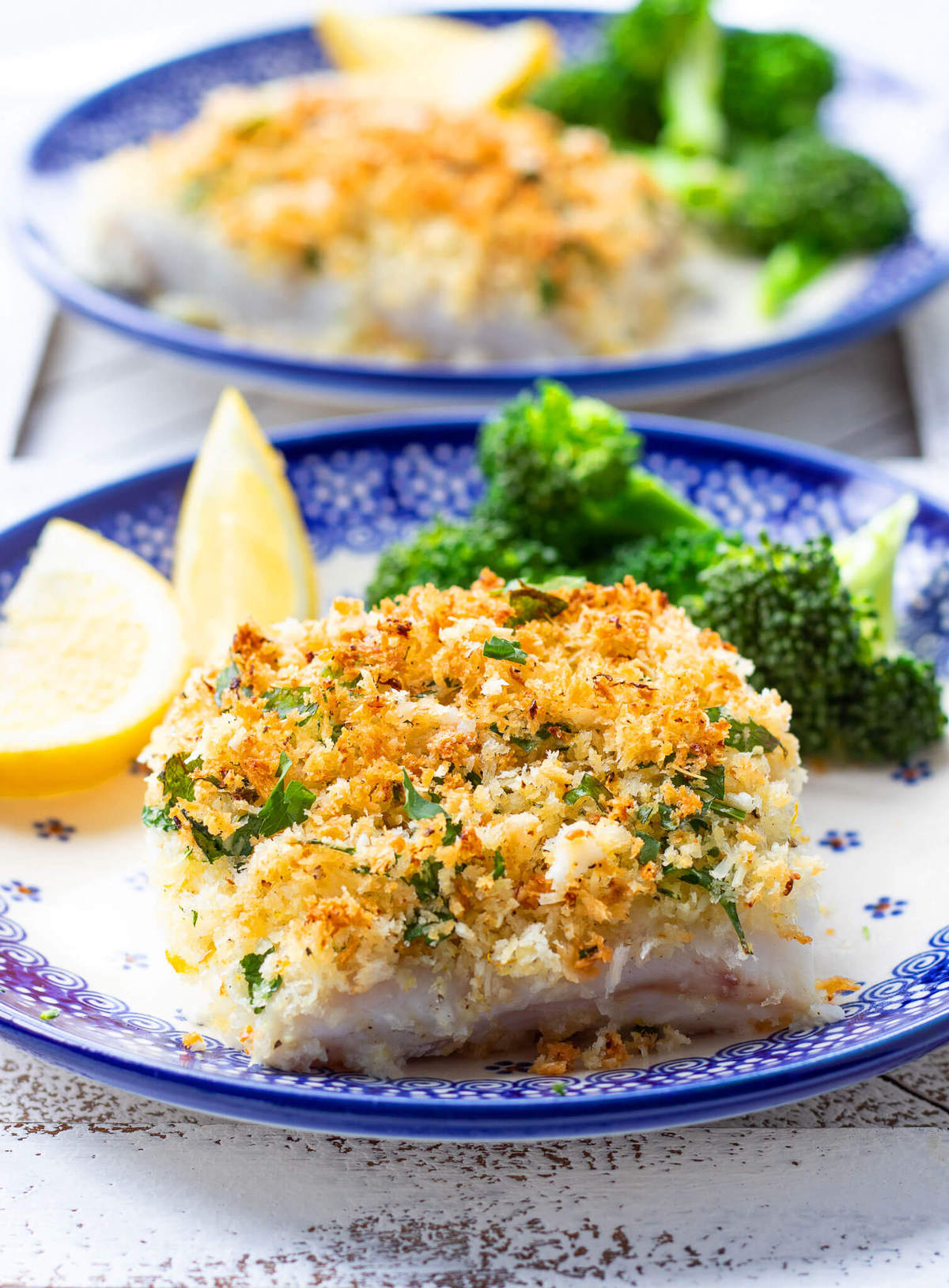 parmesan crusted cod on plate with broccoli and lemon