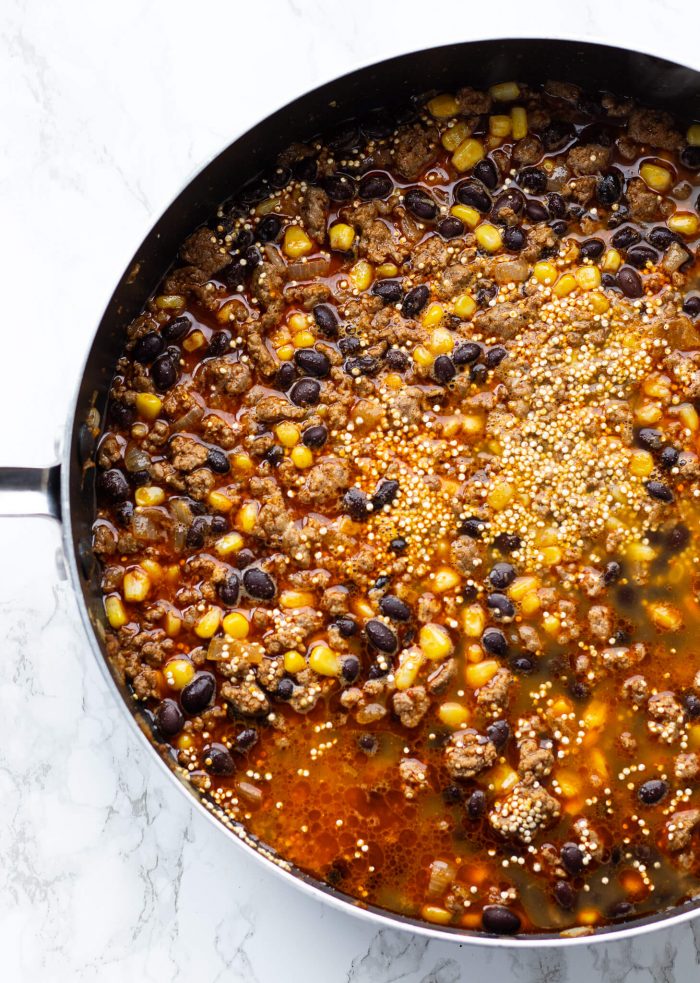 Beef, black beans, corn and quinoa cooking in a pan