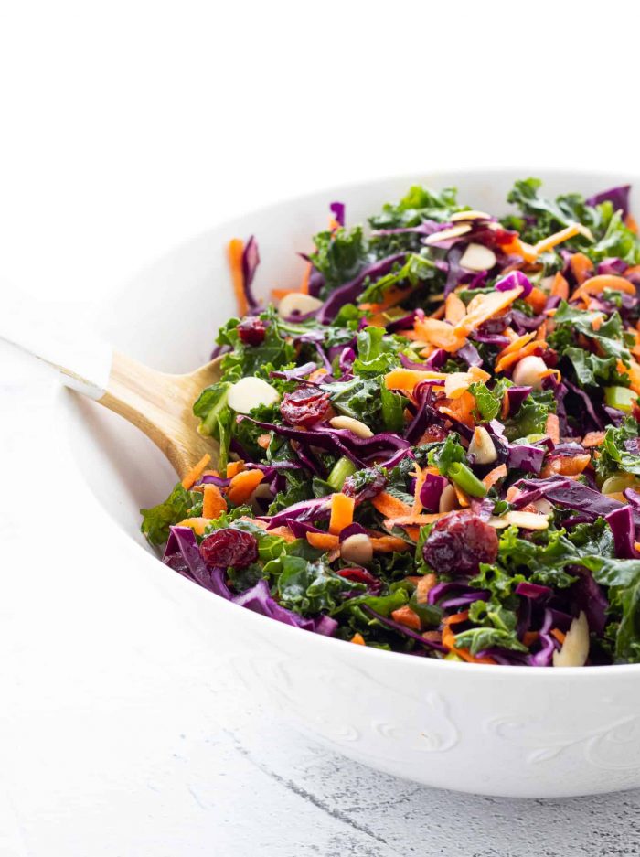 Kale salad with cranberries and almonds in a large bowl.