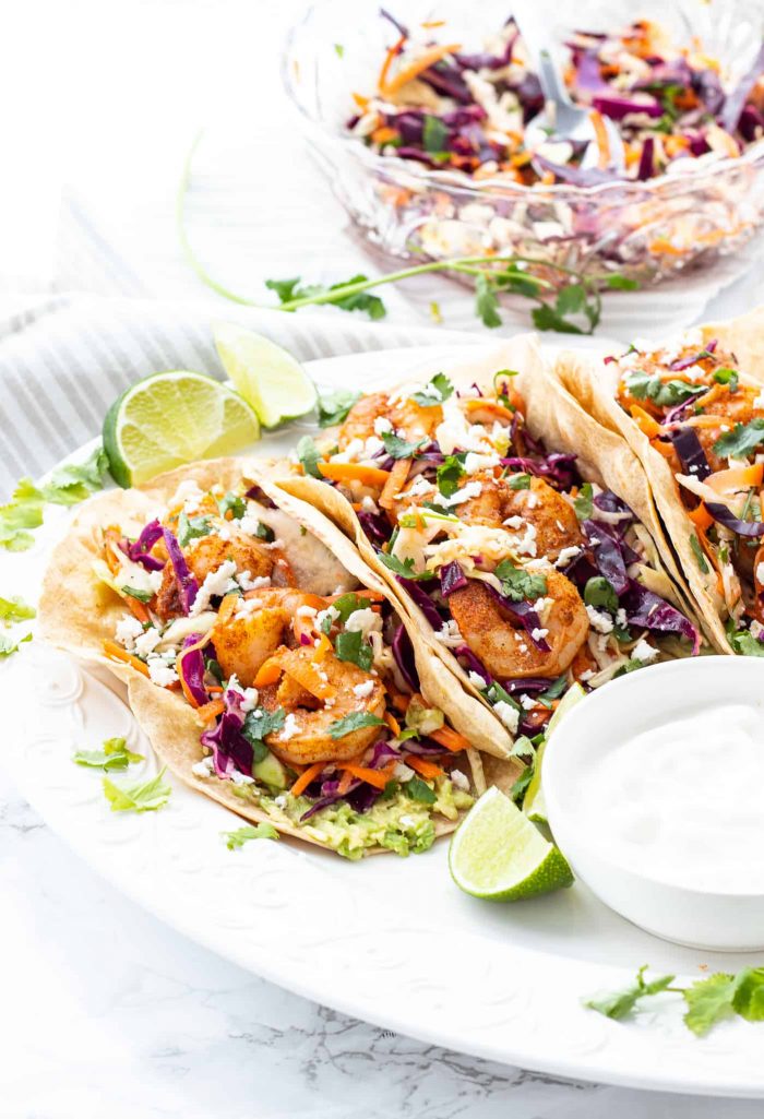 Three spicy shrimp tacos on a plate ready to eat