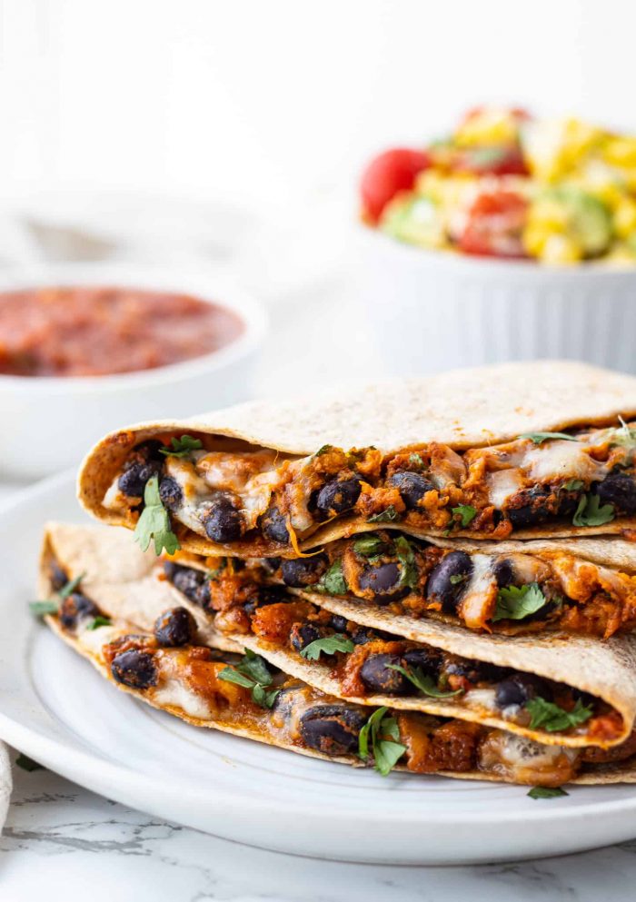 stack of black bean quesadillas with salsa and corn salad