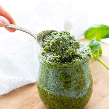 Pesto in a glass jar and on a spoon