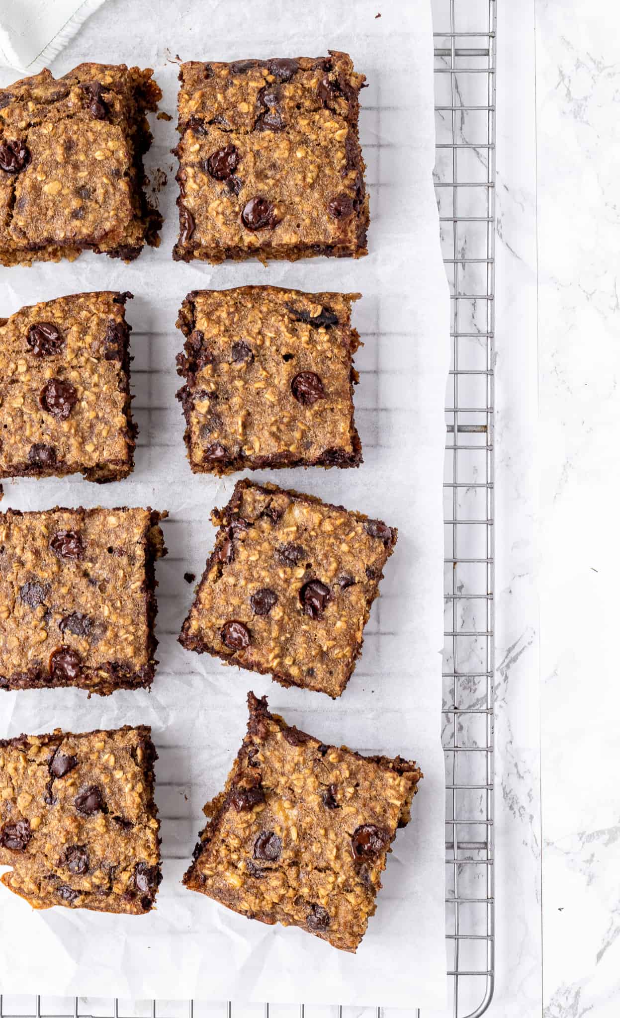 Oatmeal bars cut into squares on a cooling rack.