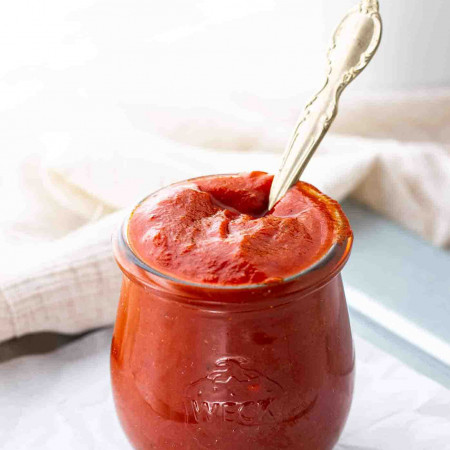 A spoon in a jar of BBQ sauce