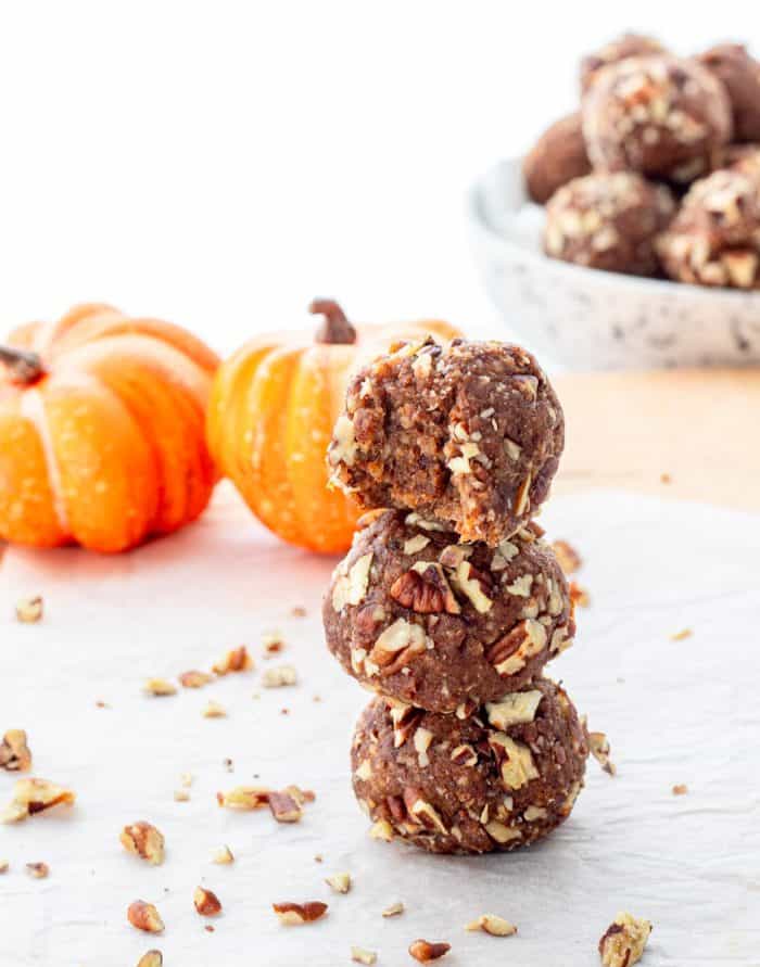 Energy balls stacked on top of each other next to mini pumpkins