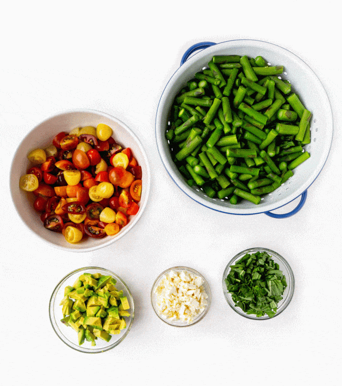 ingredients for asparagus tomato salad on a white background