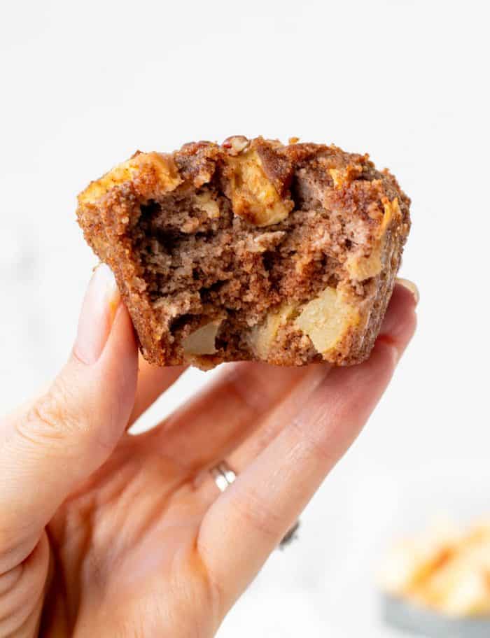 holding an apple muffin with a bite taken out of it