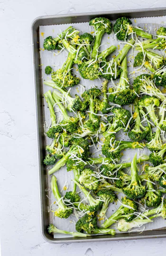 The broccoli spread out on a sheet pan before roasting.