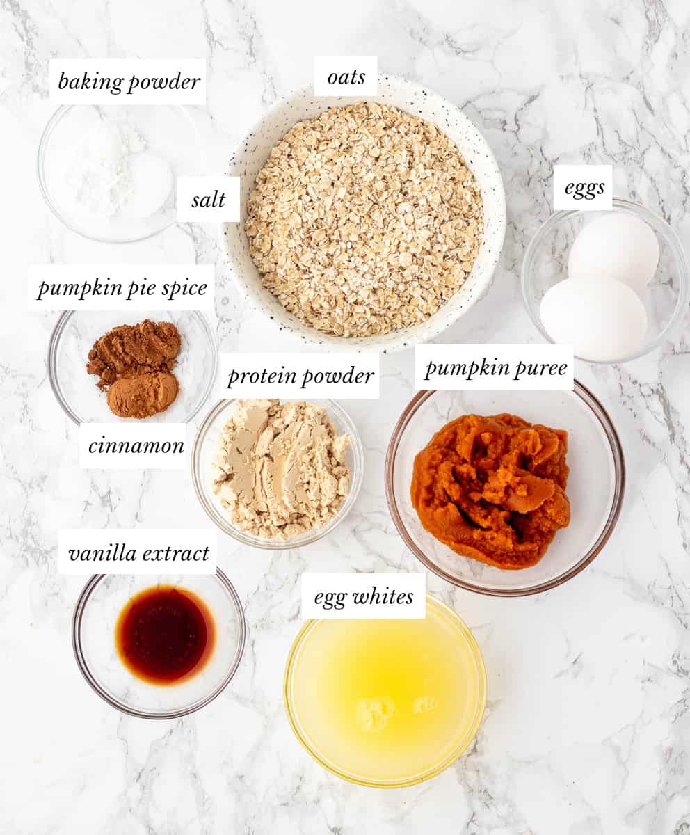 ingredients for pumpkin protein pancakes on marble background with labels