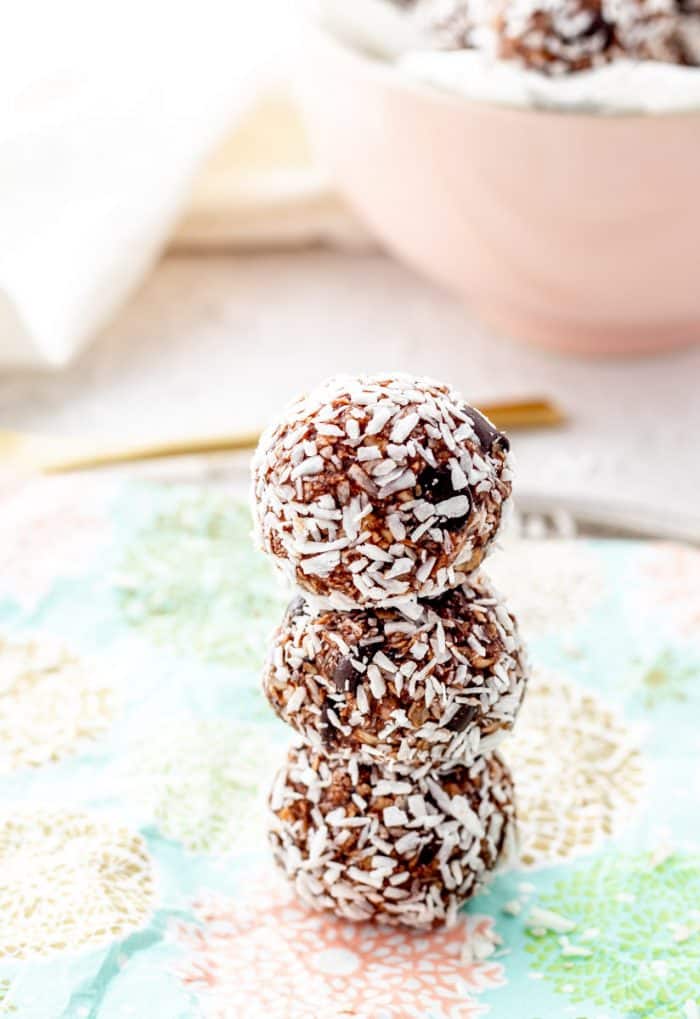 Three chocolate coconut bites stacked on top of eachother.