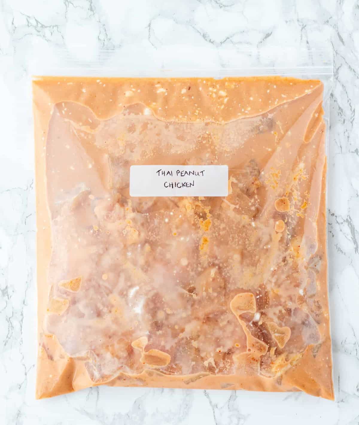 peanut chicken in freezer bag on marble background