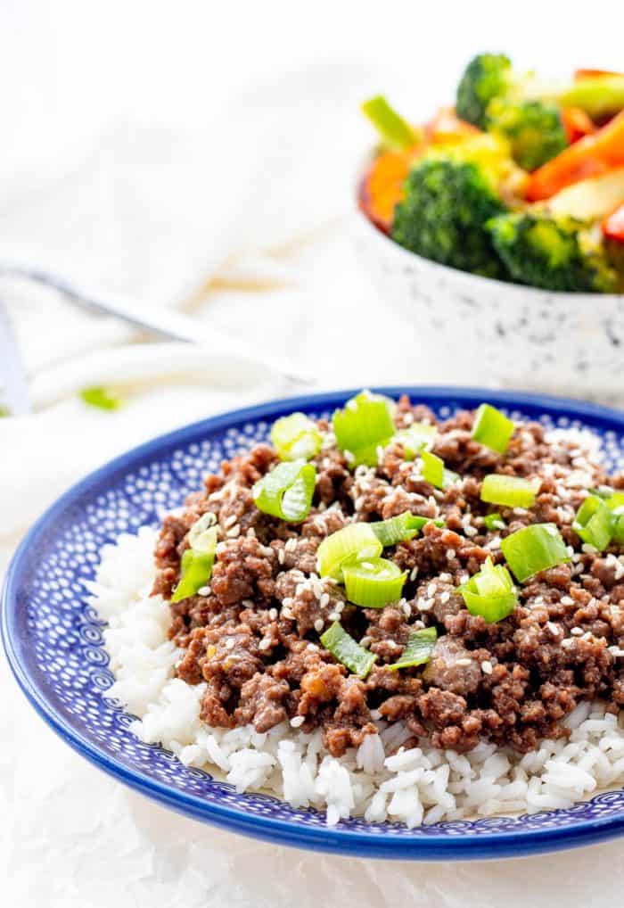 Korean ground beef next to a bowl of steamed vegetables.