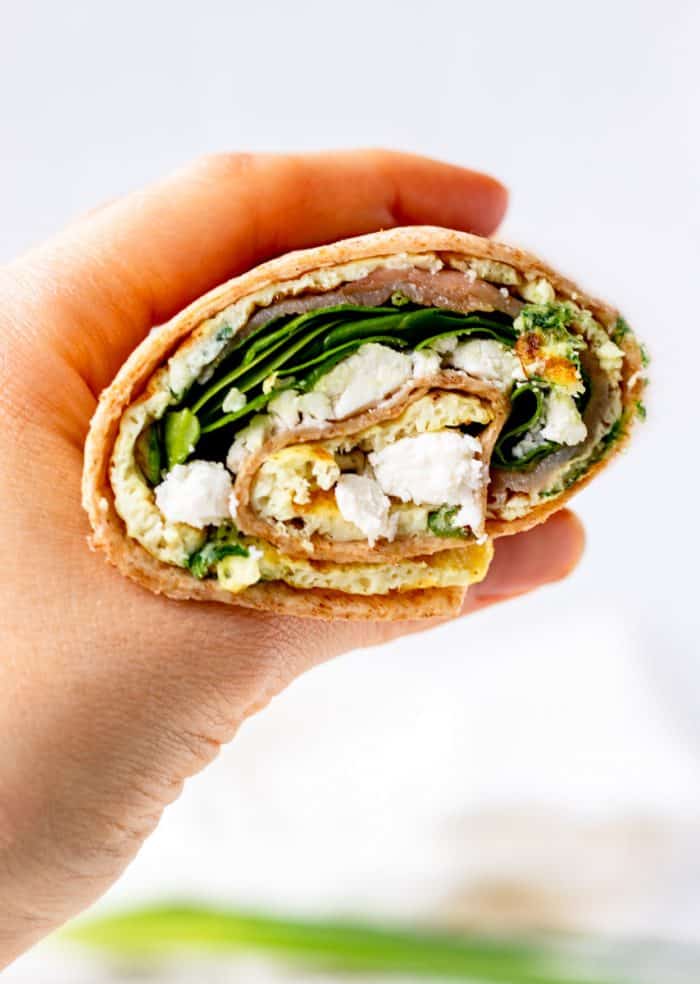 A hand holding an egg white wrap.
