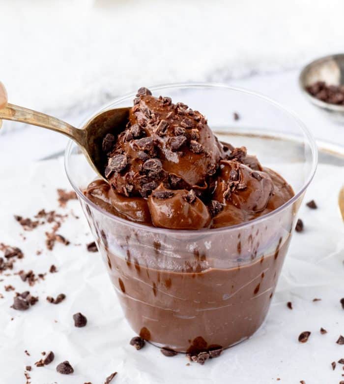 Avocado chocolate pudding being eaten with a spoon.