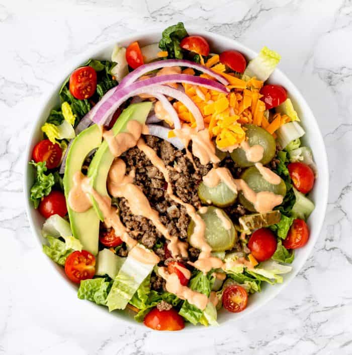 Overhead shot of a healthy burger bowl drizzled with special sauce.