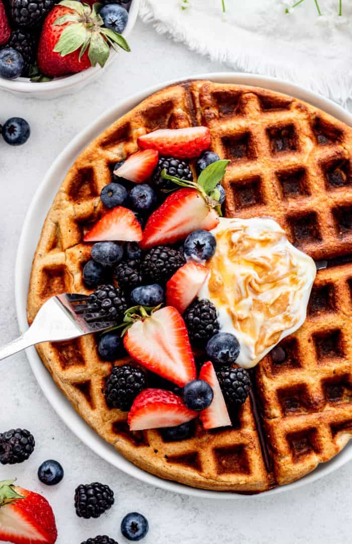 Close up of fresh berries and yogurt on freshly baked oatmeal waffles.