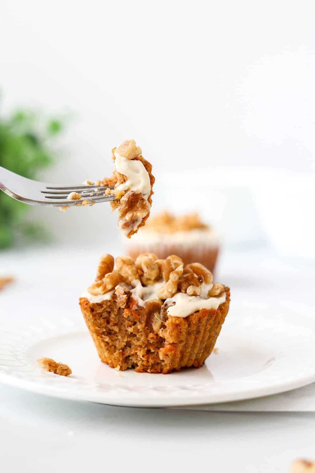 A fork taking a piece of the carrot cake muffin.