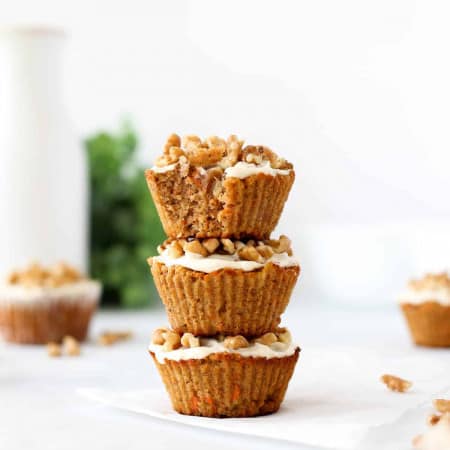 Three carrot cake muffins stacked on top of each other.