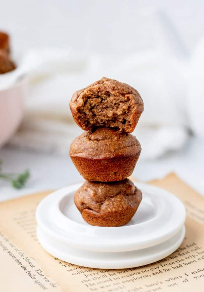 Three muffins stacked on top of each other, one with a bite taken out of it.