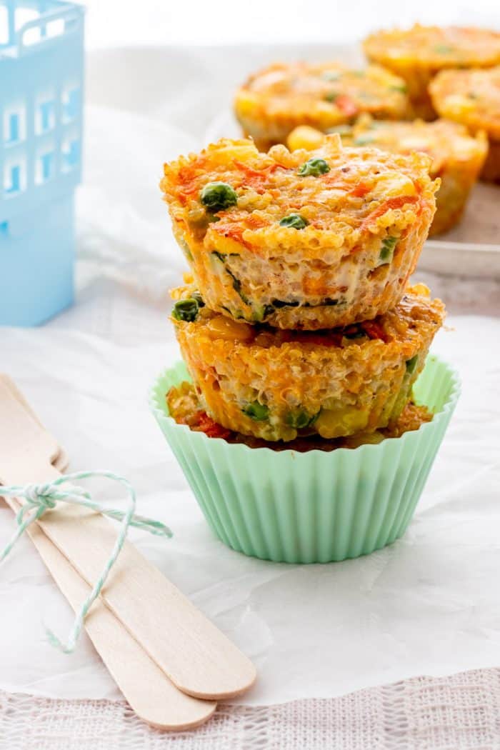 A stack of three quinoa cups in a silicone muffin cup next to two wooden forks