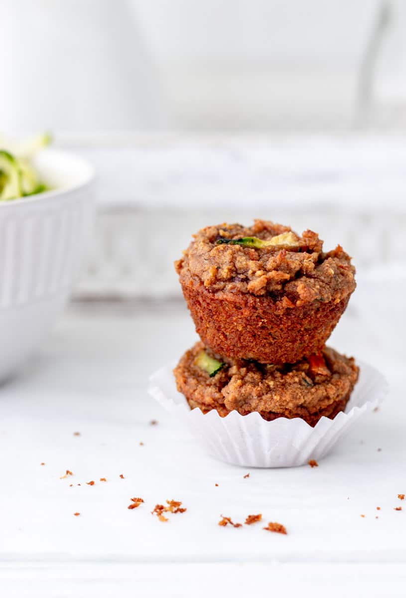 Close up of two carrot zucchini muffins stacked on top of each other.