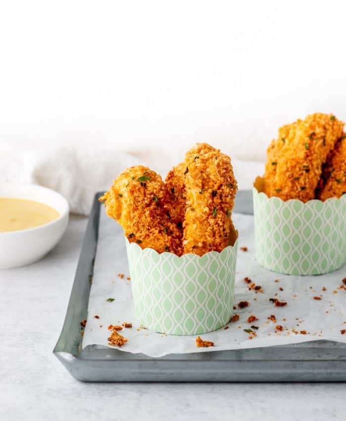 Almond coconut chicken tenders in two small containers.
