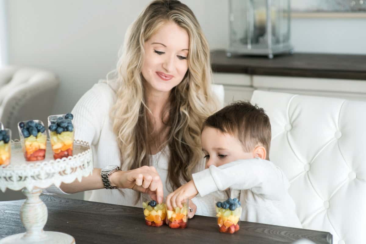 Elysia and son eating rainbow fruit cups.