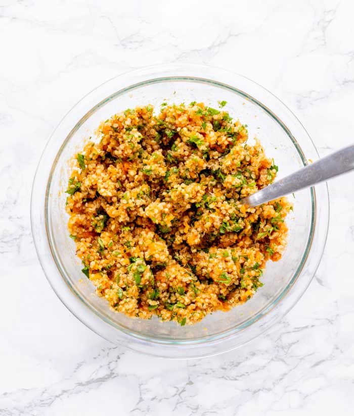 Sweet potato quinoa mixture in a glass bowl with a fork