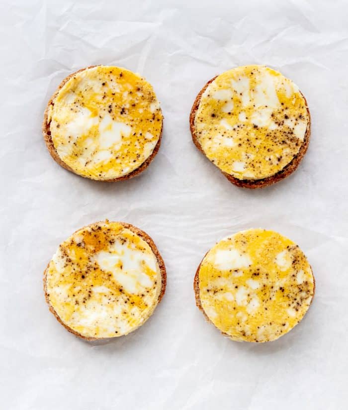 Eggs placed on top of muffins.