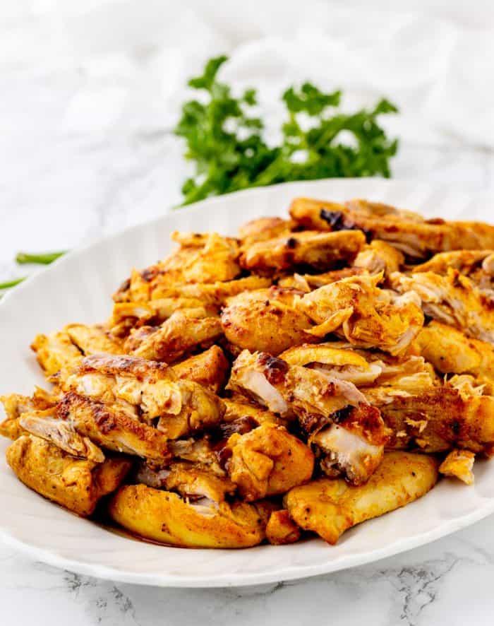 The cooked chicken shawarma on a large white serving plate.