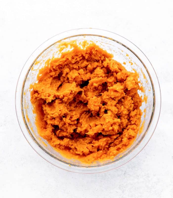 Sweet potato flesh mashed in a glass bowl