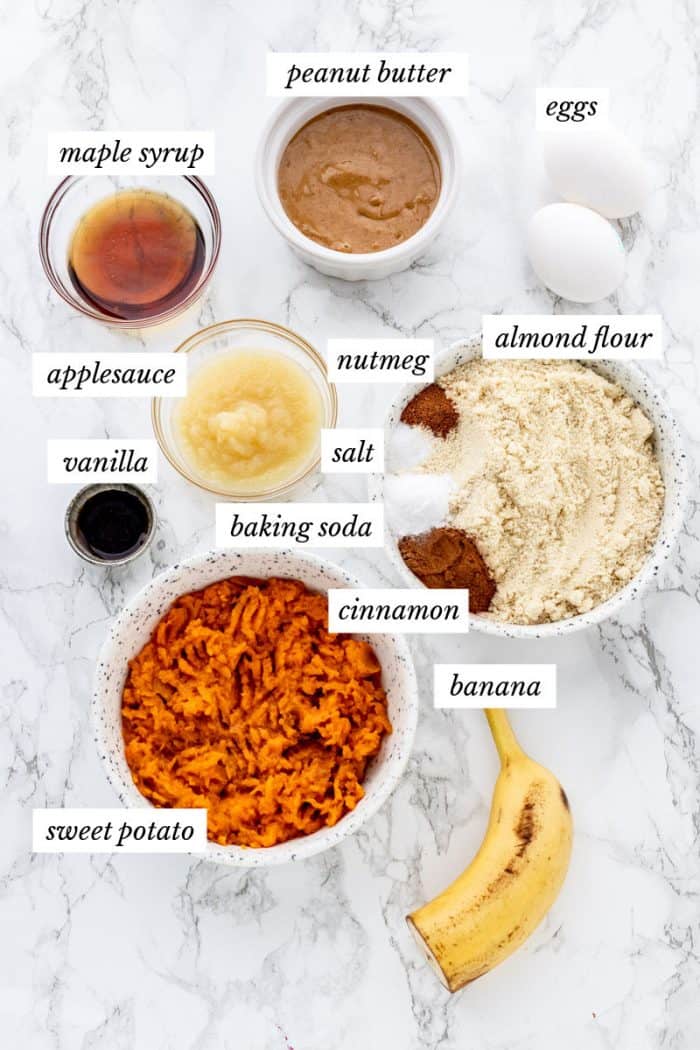 Ingredients for sweet potato muffins on marble background with labels