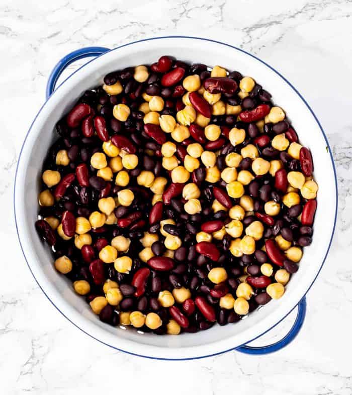3 types of beans for chili in a blue and white colander