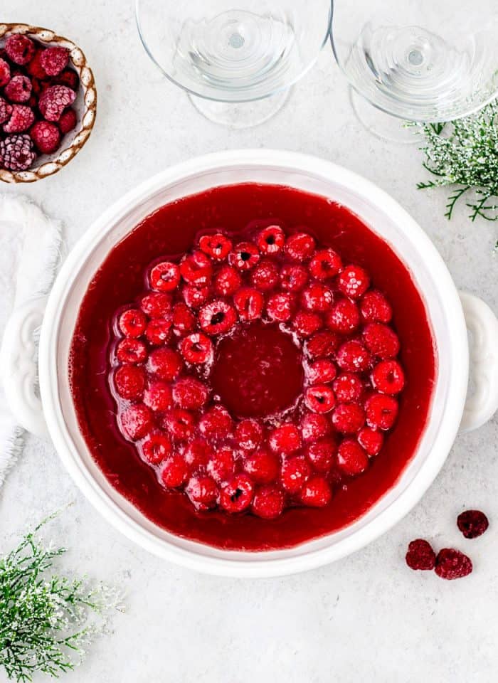 a ring of raspberries in a large bowl of punch