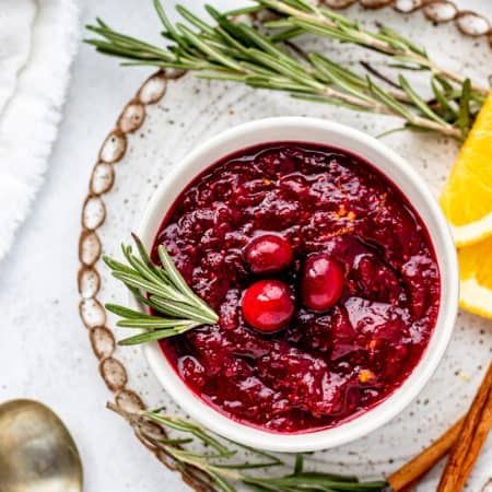 A sprig of rosemary in a bowl of healthy cranberry sauce.