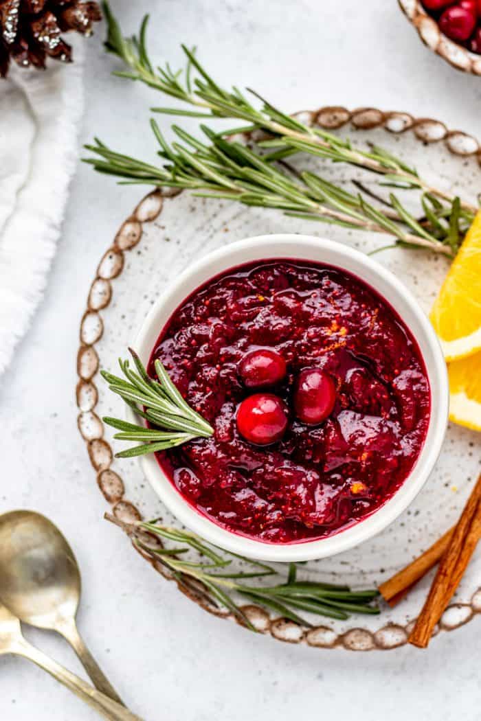 A sprig of rosemary in a bowl of healthy cranberry sauce.