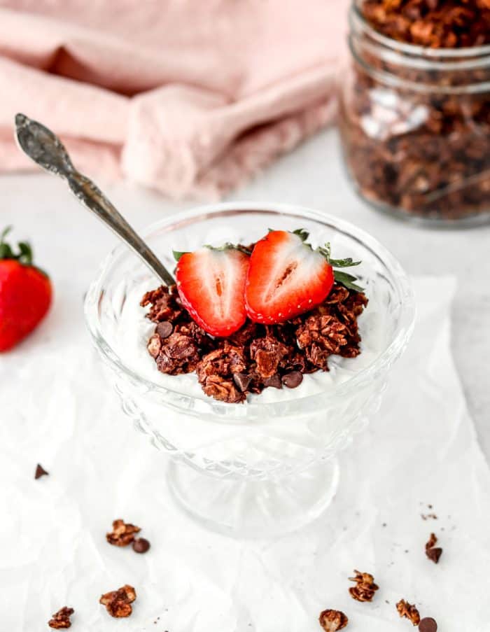 Chocolate granola served on yogurt with fresh strawberries.