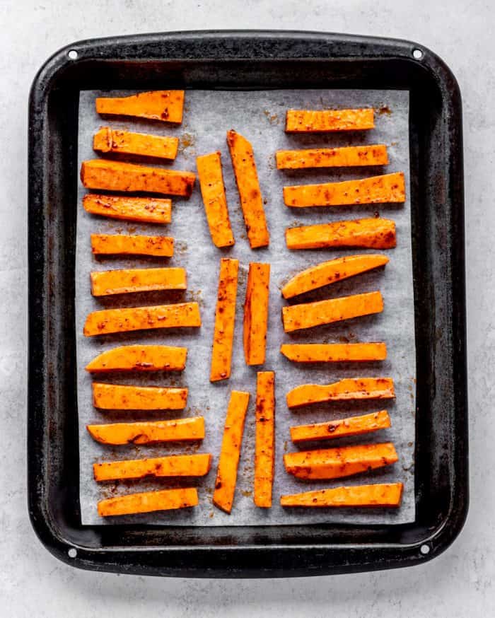 cut up sweet potato fries on a baking sheet.